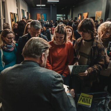 Długa kolejka gości z książkami do podpisania