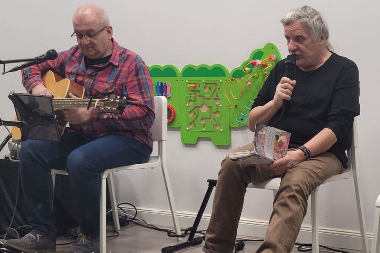 Marek Biniek gra na gitarze i Krzysztof Kasperczyk śpiewa