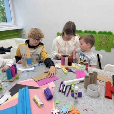 Dzieci przy pracy plastycznej, na stole leżą różne materiały