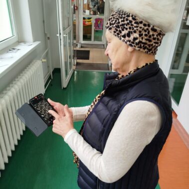 Uczestniczka wybiera zdjęcia na smartfonie