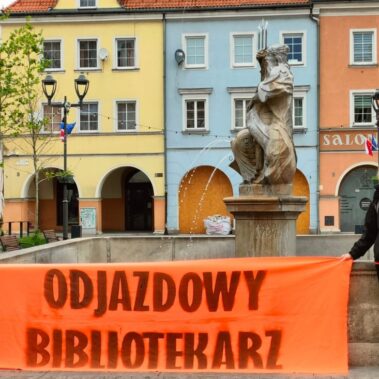 Na rynku koło fontanny Neptuna, bibliotekarki trzymają baner "Odjazdowy bibliotekarz"