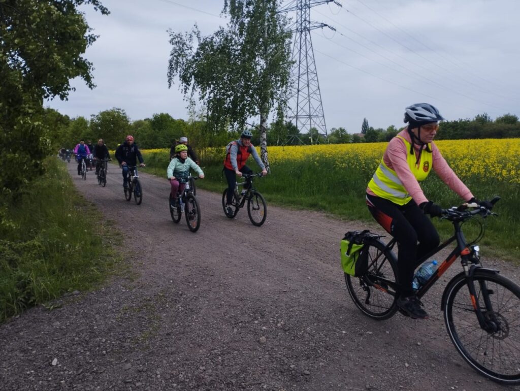 Gdzieś w Gliwicach, uczestnicy jeżdżą rowerami po drogach polnych