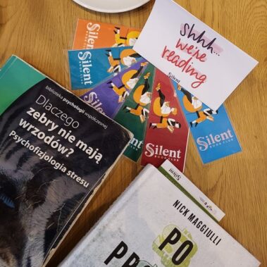 Na stoliku leżą zakładki, książki i filiżanka herbaty