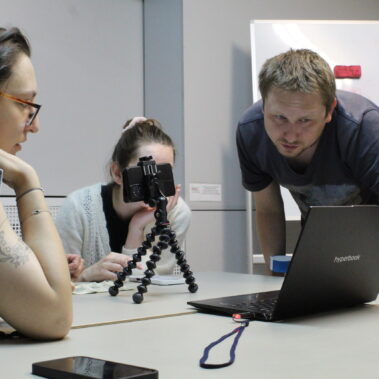 Pan wyjaśnia uczestniczkom zdjęcie na ekranie laptopa