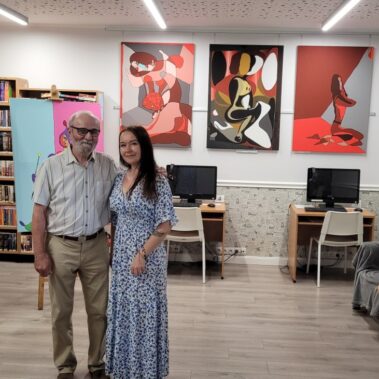 Józef Bujara i bibliotekarka, z tyłu na ścianach wiszą jego obrazy
