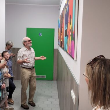 Odprowadzenie gości po wystawie. Józef Bujara omawia na temat obrazów