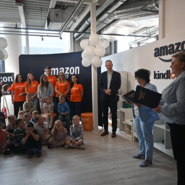 Dyrektor Biblioteki Bogna Dobrakowska przemawia w otoczeniu pracowników, wolontariuszy z Amazona i dzieci
