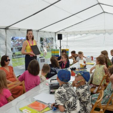 Pani pokazuje dzieciom za pomocą tableta