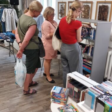 Panie przeglądają zbiory książek i płyt winylowych
