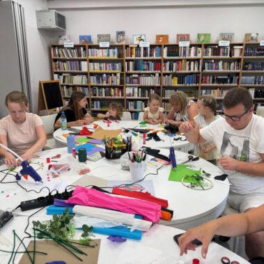 Uczestnicy przy pracy, na stole leżą różne materiały