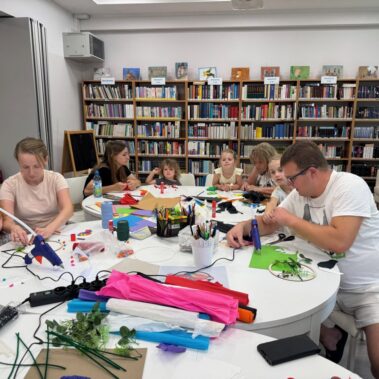 Uczestnicy przy pracy, na stole leżą różne materiały