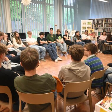 Młodzież siedzą w kółko i trwa dyskusja