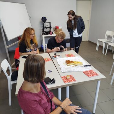 Uczestnicy oglądają aparatu fotograficznego