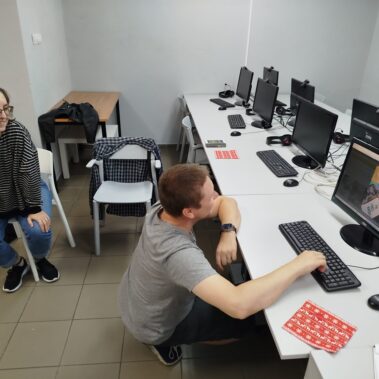 Uczestnicy oglądają zdjęcia na laptopie