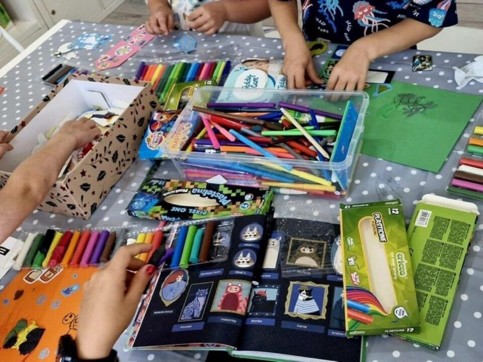 Ręce przy pracy, na stole leżą różne materiały