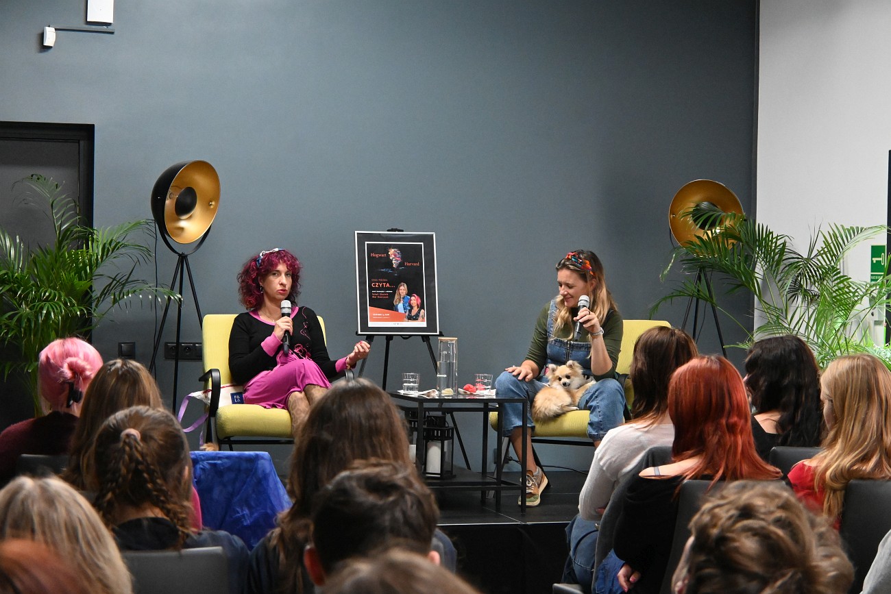 Na scenie siedzą Sylwia Chutnik i Maria Hawranek, młodzież słuchają