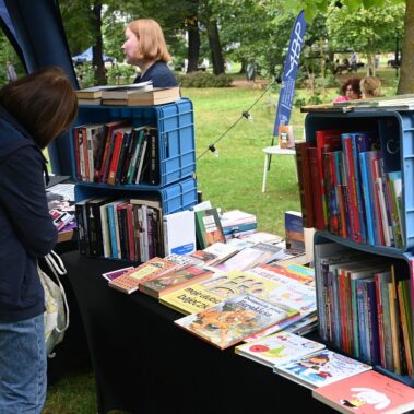 Stoisko biblioteki i pani przegląda książki