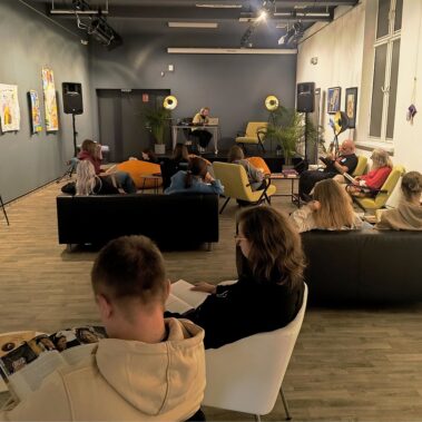 Reading Party w Bibliotece czyli Muzyka dla Książek — widok na salę, uczestnicy czytają, na scenie DJ
