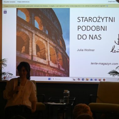 Widok na salę, Julia Woller prowadzi wykład. Na ekranie jest wyświetlany slajd o "Starożytni podobni do nas"