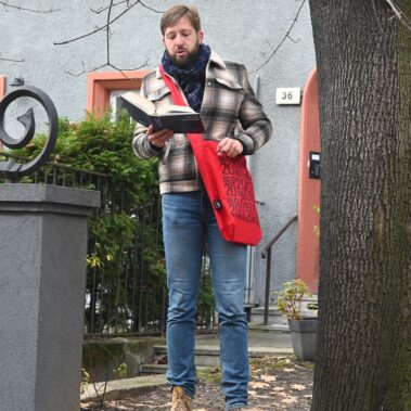 Na ulicy Konarskiego przed domem, Jakub Kornhauser czyta książkę