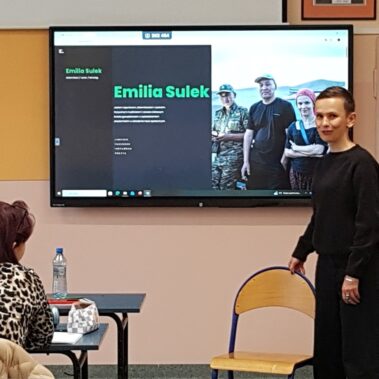 Emilia Sułek mówi, a na ścianie jest wyświetlanie zdjęcie