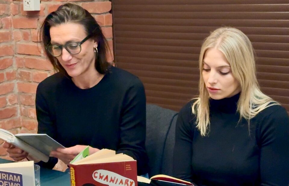 Klaudia Cygoń-Majchrowska i Aleksandra Maj siedzą przy stole, i czytają na głos