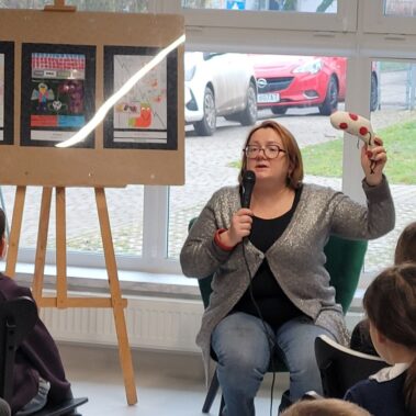 Justyna Bednarek pokazuje skarpetkę i mówi, dzieci słuchają.