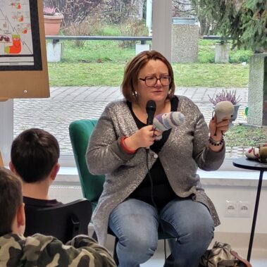 Justyna Bednarek pokazuje die skarpetki i mówi, dzieci słuchają.