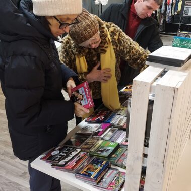 Panie przeglądają zbiory audioteki, filmów na płytach DVD