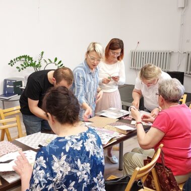 Uczestnicy przy pracy, a stole leżą różne materiały