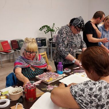 Panie przy pracy, a stole leżą różne materiały