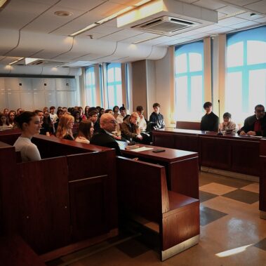 Widok ogólny na salę sądową z młodzieżami i stymulowaną rozprawą sądową