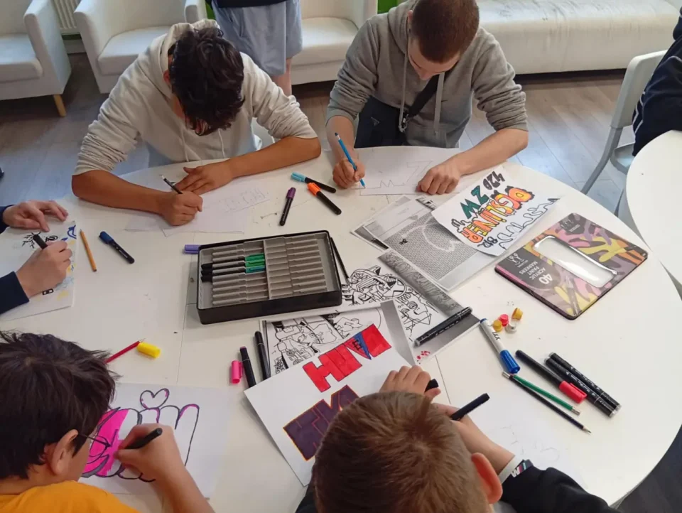 Uczestnicy malują graffiti na podstawie własnego pomysłu i przykładowych ilustracji.