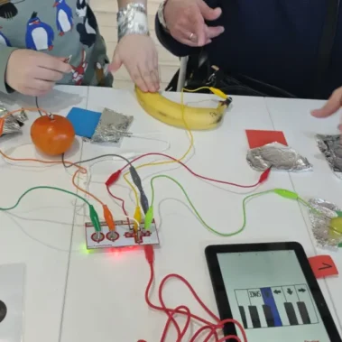 Trwa eksperymenty przy użyciu Makey Makey z użyciem folii, owoców