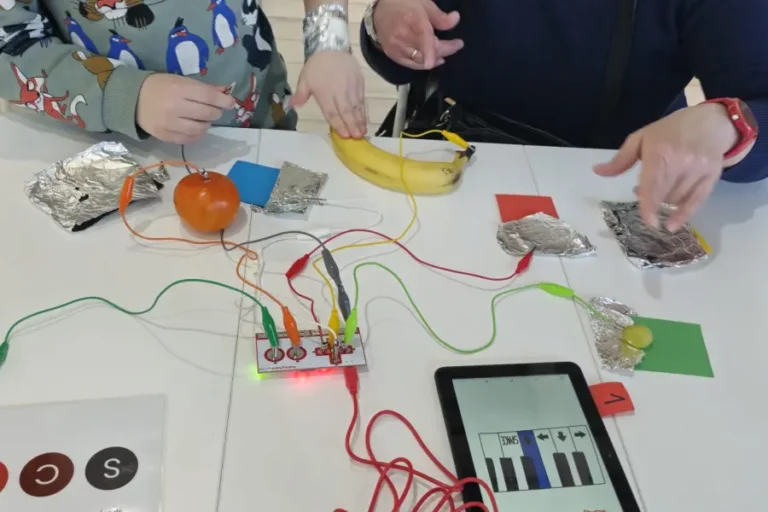 Trwa eksperymenty przy użyciu Makey Makey z użyciem folii, owoców