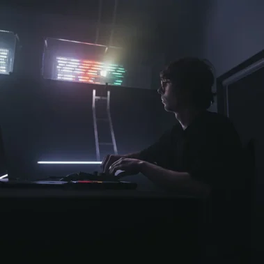 Drugi operator przy pulpicie z laptopem , lampy świecą na różne wzory w różnych kolorach